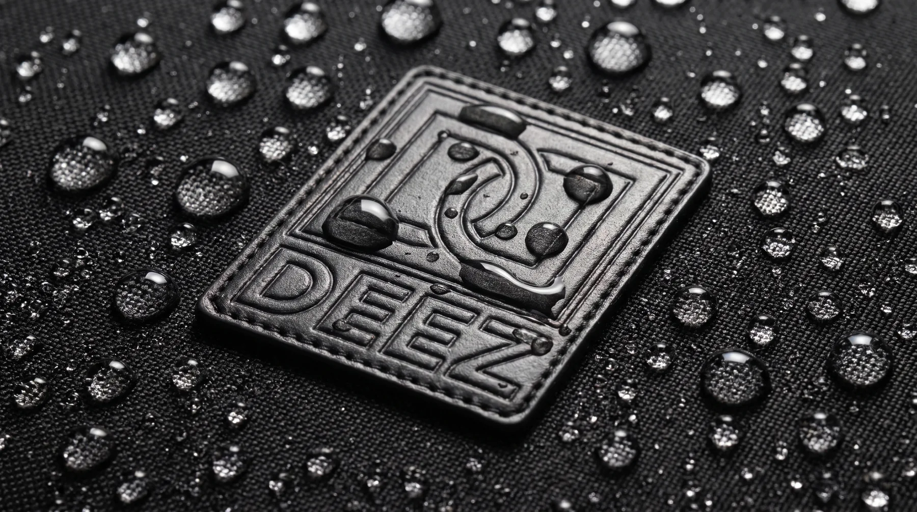 Water droplets beading on the black fabric around the Double Deez Goodz logo patch.